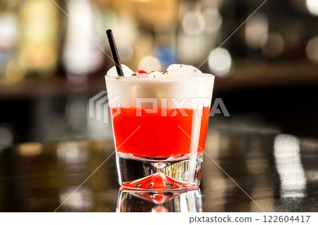 Closeup glass of special sex on beach cocktail decorated with cream at bar counter. Closeup glass of special sex on beach cocktail decorated with cream at bar counter. 122604417
