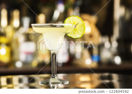Closeup glass of margarita cocktail decorated with lime at bar background. Closeup glass of margarita cocktail decorated with lime at bar background. 122604592