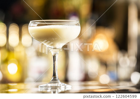 Closeup glass of milk liquor based cocktail at bright bar counter background. 122604599