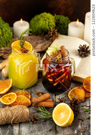 Two mugs of xmas mulled wine at decorated with candles, book and moss wooden table background. Two mugs of xmas mulled wine at decorated with candles, book and moss wooden table background. 122604628
