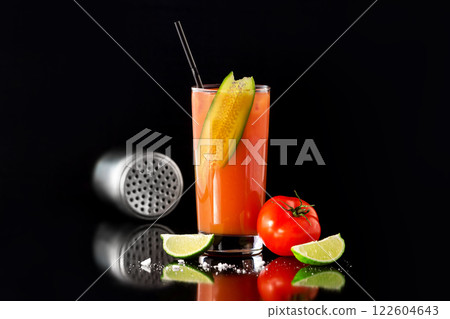Fresh glass of bloody mary cocktail decorated with lime and cucumber isolated at black background. 122604643