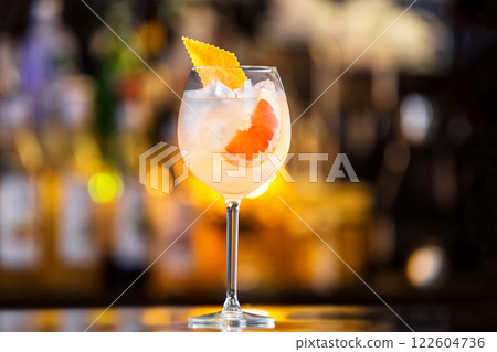 Closeup glass of sparkling wine cocktail decorated with grapefruit at bar counter background. Closeup glass of sparkling wine cocktail decorated with grapefruit at bar counter background. 122604736