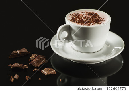 Closeup image of white cup full of latte coffee at dark background. Closeup image of white cup full of latte coffee at dark background. 122604773