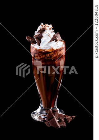 Vertical image of glass of chocolate milkshake decorated with whipped milk isolated at black background. Vertical image of glass of chocolate milkshake decorated with whipped milk isolated at black background. 122604819