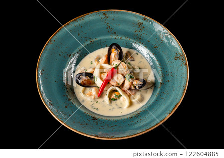 Plate of seafood saute with prawns, calamari and sauce isolated at black background. Plate of seafood saute with prawns, calamari and sauce isolated at black background. 122604885