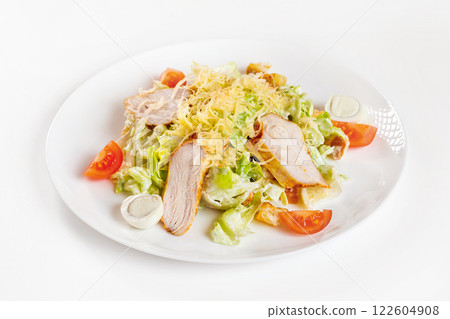 Closeup image of caesar salad with chicken on plate isolated at white background. Closeup image of caesar salad with chicken on plate isolated at white background. 122604908