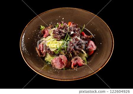 Plate of roast beef salad  with fresh tomatoes, salad mix with ginger sauce and parmesan cheese isolated at black background. 122604926