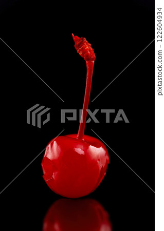 Macro image of single cocktail cherry with reflection isolated at black background. 122604934