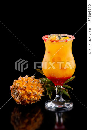 Closeup glass of mai tai cocktail decorated with pineapple isolated at black background. Closeup glass of mai tai cocktail decorated with pineapple isolated at black background. 122604940