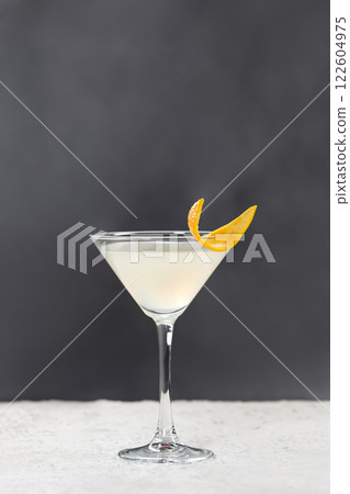 Glass of clear margarita cocktail served with lemon at grey background with copyspace Glass of clear margarita cocktail served with lemon at grey background with copyspace 122604975