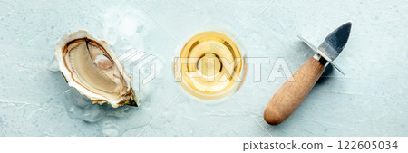 Oyster with a glass of wine, on ice, on a slate background Oyster with a glass of wine, on ice, on a slate background 122605034