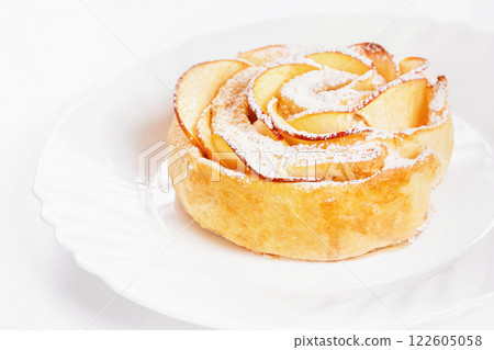 Sweet rose style twisted cake of pastry puff on plate isolated at white background. Sweet rose style twisted cake of pastry puff on plate isolated at white background. 122605058