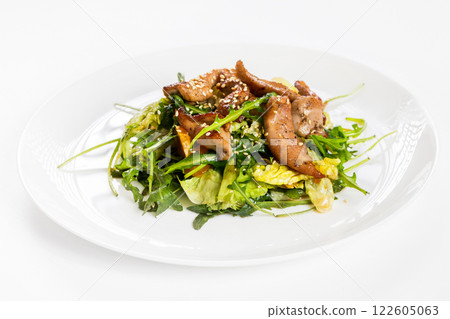 Closeup image of roasted duck at plate with green salad isolated at white background. 122605063