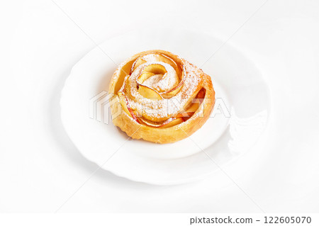 Sweet rose style twisted cake of pastry puff on plate isolated at white background. Sweet rose style twisted cake of pastry puff on plate isolated at white background. 122605070