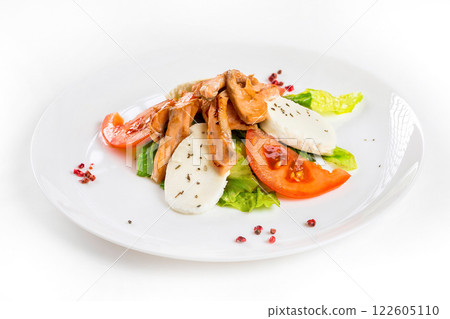 Plate of grilled salmon fish with cheese and vegetables isolated at white background. Plate of grilled salmon fish with cheese and vegetables isolated at white background. 122605110