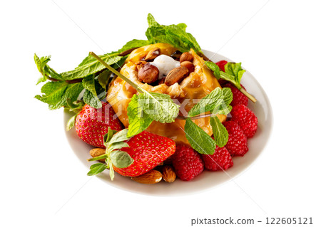 Closeup plate of baked apple served with strawberries, raspberries, nuts, mint and caramel isolated at white background. Concept of healthy lifestyle. Closeup plate of baked apple served with strawberries, raspberries, nuts, mint and caramel isolated at white background. Concept of healthy lifestyle. 122605121