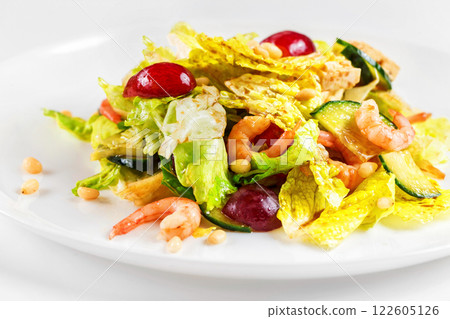 Plate of shrimps salad with soy-bean sauce and green vegetables isolated at white background. 122605126