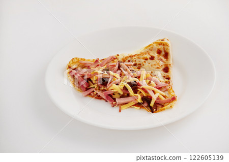 Traditional Russian meal blin stuffed with ham, cheese and mushrooms on plate isolated at white background. Traditional Russian meal blin stuffed with ham, cheese and mushrooms on plate isolated at white background. 122605139