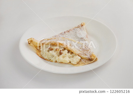 Closeup image of plate with blin - pancake with curd and raisins isolated at white background. 122605216