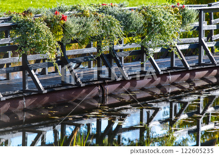 A floating wooden bridge over a duck pond in Vecpiebalga, Latvia A floating wooden bridge over a duck pond in Vecpiebalga, Latvia 122605235
