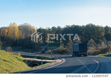 Rear view of a truck on a bend in an autumn road 122605597