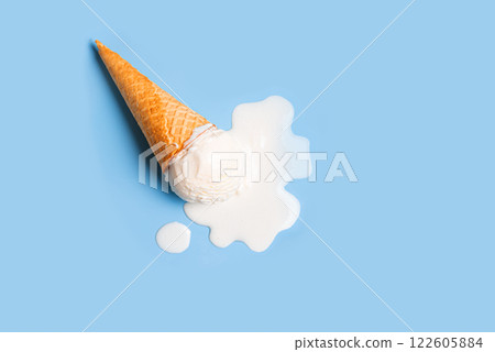 White ice cream melting and spilling from waffle cone 122605884