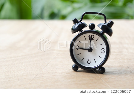 Table alarm clock pointing at 9pm or 9am with customizable space for text. Time management concept and copy space 122606097
