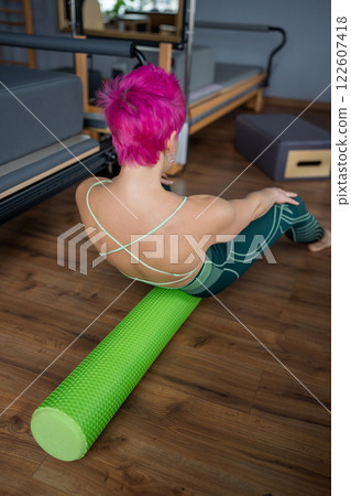 Discover the benefits of Pilates with a Foam Roller in a modern and inviting studio 122607418