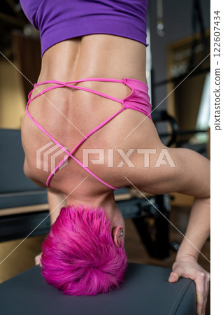 Pilates fitness trainer beautiful back relief. Pilates studio. Young sporty attractive woman wearing sportswear in yoga studio. Fit, healthy and strong authentical body. Fitness concept 122607434