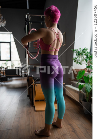 Pilates fitness trainer beautiful back relief. Pilates studio. Young sporty attractive woman wearing sportswear in yoga studio. Fit, healthy and strong authentical body. Fitness concept 122607456