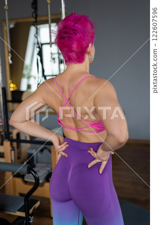Pilates fitness trainer beautiful back relief. Pilates studio. Young sporty attractive woman wearing sportswear in yoga studio. Fit, healthy and strong authentical body. Fitness concept 122607596