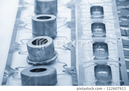 Sample of stamping part of metal drawing process on the progressive die in the light blue scene. 122607911