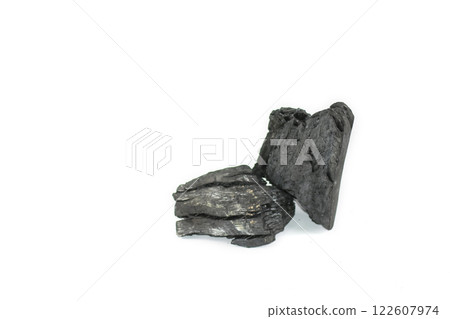 Isolated pieces of black charcoal resting on a clean white background, showcasing its rough texture and deep, rich color. Often used for grilling, art, and filtration. 122607974