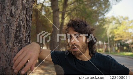 Young Man Hot In Summer Waving His Hand And Breathing Exhausted Near Trees Young Man Hot In Summer Waving His Hand And Breathing Exhausted Near Trees 122608054
