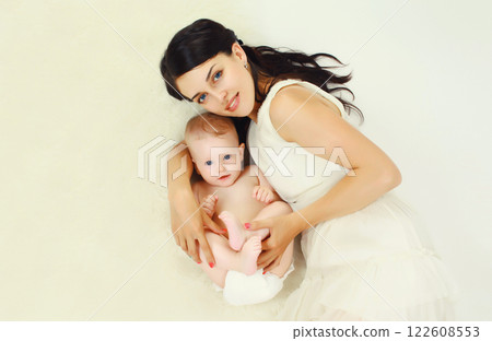happy young mother lying with baby together at home happy young mother lying with baby together at home 122608553