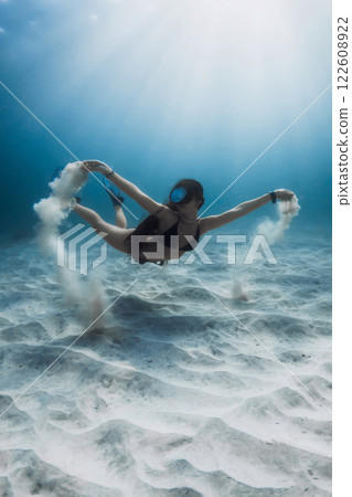 Freediver woman posing underwater with sand in hands. Freediving and beautiful sunlight with attractive woman. Freediver woman posing underwater with sand in hands. Freediving and beautiful sunlight with attractive woman. 122608922
