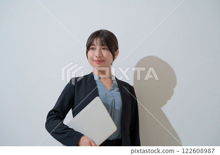Smiling Japanese business woman holding a laptop 122608987