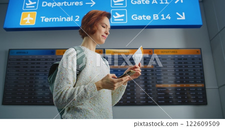 Happy Woman Scanning Plane Ticket Using Smartphone, Smiling, Going to Boarding Flight Happy Woman Scanning Plane Ticket Using Smartphone, Smiling, Going to Boarding Flight 122609509