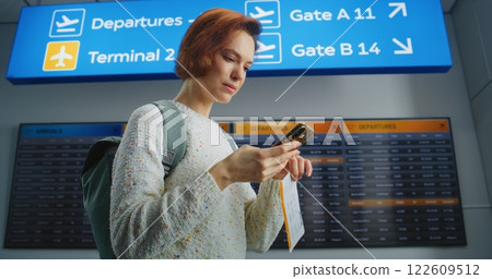 Happy Female Passenger Scanning Plane Ticket Using Phone, Going to Boarding Flight 122609512