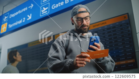 Airport Terminal: Happy Man Scanning Plane Ticket Using Smartphone 122609575