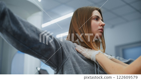 Airport Terminal: Female Security Officer in Gloves Checks Female Passenger Body for Boarding Flight 122609579
