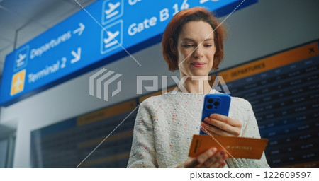Woman Scanning Plane Ticket Using Smartphone to Check Flight Information Woman Scanning Plane Ticket Using Smartphone to Check Flight Information 122609597