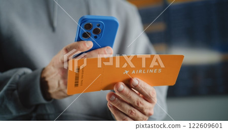Airport Terminal: Close Up of Male Passenger Scanning Plane Ticket Using Smartphone Airport Terminal: Close Up of Male Passenger Scanning Plane Ticket Using Smartphone 122609601