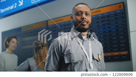 Airport Terminal: TSA Worker in Uniform Looking at Camera Airport Terminal: TSA Worker in Uniform Looking at Camera 122609606