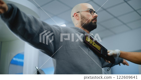 Airport Terminal: Security Officer Inspects Man Body Using Metal Detector Airport Terminal: Security Officer Inspects Man Body Using Metal Detector 122609641
