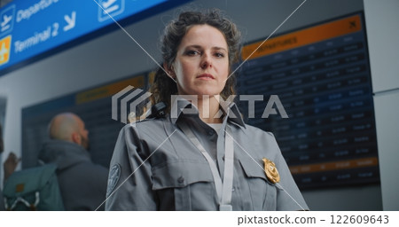 Portrait of Security Officer in Airport Terminal: Female TSA Worker in Uniform Looking at Camera Portrait of Security Officer in Airport Terminal: Female TSA Worker in Uniform Looking at Camera 122609643