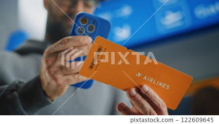 Airport Terminal: Close Up of Man Scanning Plane Ticket Using Smartphone Airport Terminal: Close Up of Man Scanning Plane Ticket Using Smartphone 122609645