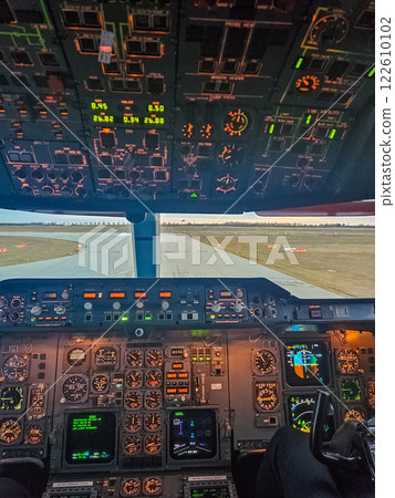 Illuminated cockpit view of an aircraft ready for takeoff at sunrise. High quality photo 122610102