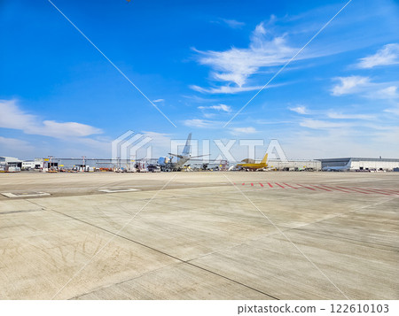 Airport tarmac with parked planes under a blue sky with scattered clouds. High quality photo Airport tarmac with parked planes under a blue sky with scattered clouds. High quality photo 122610103