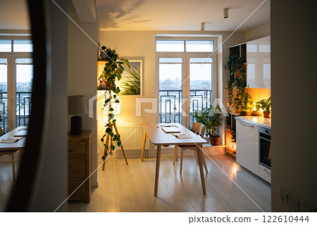 Inviting apartment interior with soft lamp light reflect in mirror, warm glow up kitchen and hallway Inviting apartment interior with soft lamp light reflect in mirror, warm glow up kitchen and hallway 122610444
